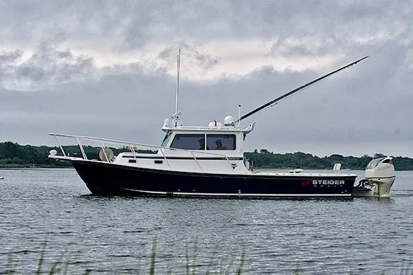 Slide: The Image of 2026 Steiger Craft 31 Miami boat on calm water under cloudy sky. - 3