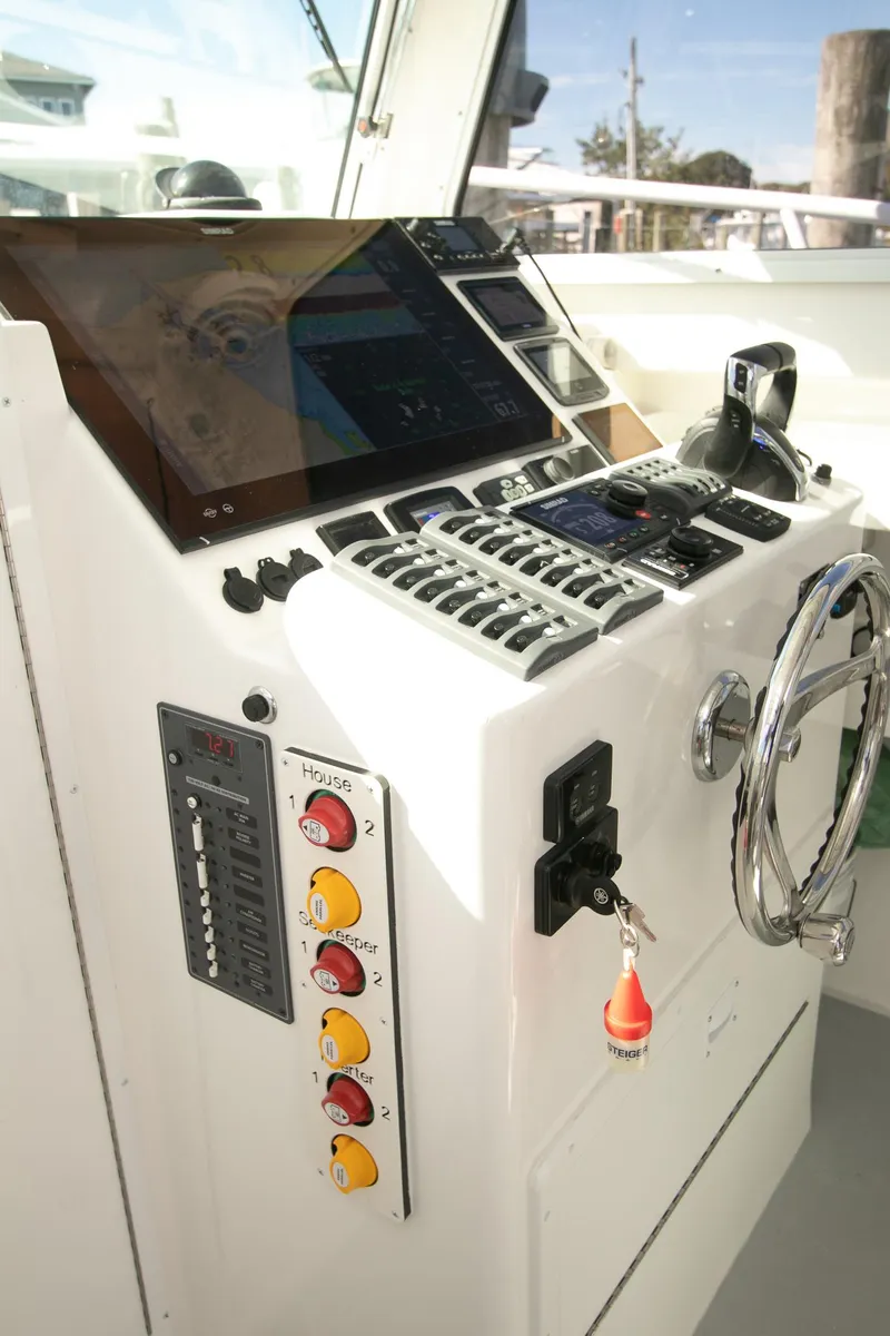 Slide: The Image of Control panel of 2026 Steiger Craft 31 Miami boat with steering wheel and navigation equipment. - 32