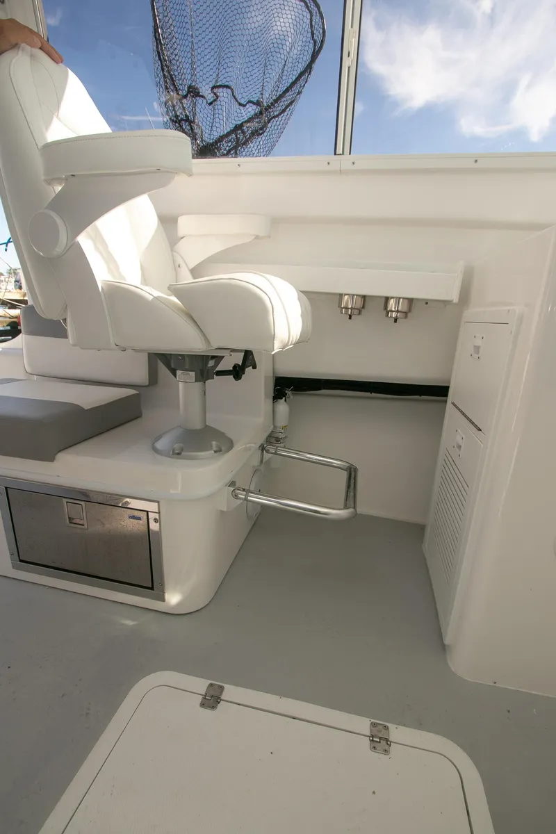Slide: The Image of Interior of 2026 Steiger Craft 31 Miami boat with white captain's chair and storage. - 37