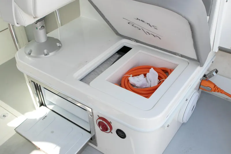 Slide: The Image of 2026 Steiger Craft 31 Miami boat storage compartment with orange hose and electrical connection. - 40