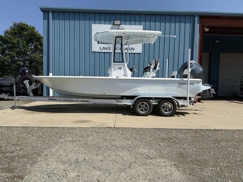 The Image of 2026 Tidewater 2110 BM boat on trailer, parked outside a blue building. - 1