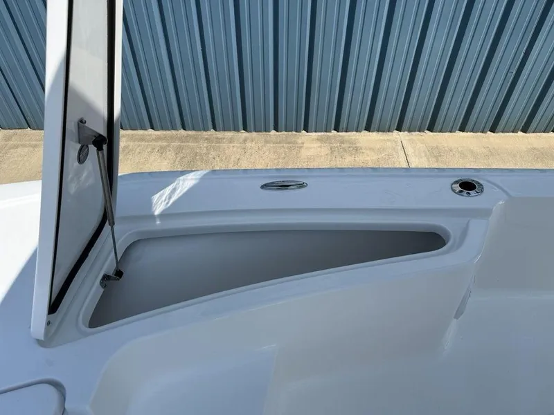 Slide: The Image of Open storage compartment on 2026 Tidewater 2110 BM boat, against blue corrugated wall. - 14