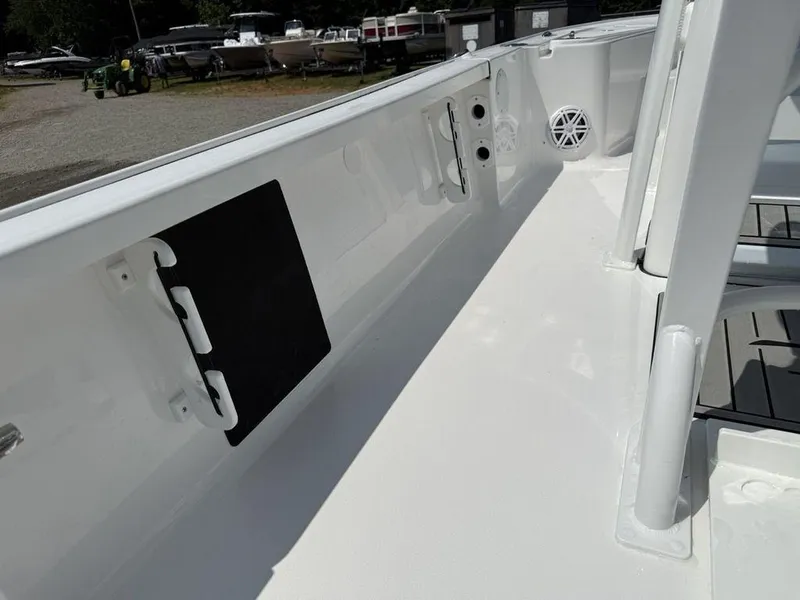 Slide: The Image of 2026 Tidewater 2110 BM boat interior with rod holders and speaker, in a marina setting. - 25