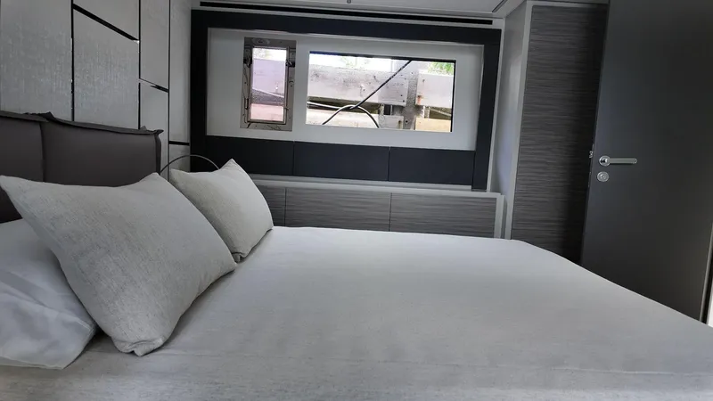 Slide: The Image of Luxurious bedroom interior of 2022 Pershing 6X yacht with modern design and window view. - 11