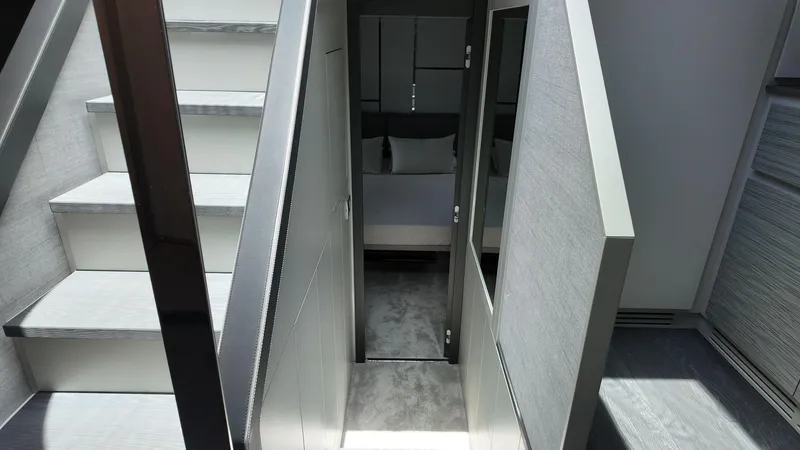 Slide: The Image of Interior of 2022 Pershing 6X yacht, featuring modern stairs and a cozy bedroom. - 15