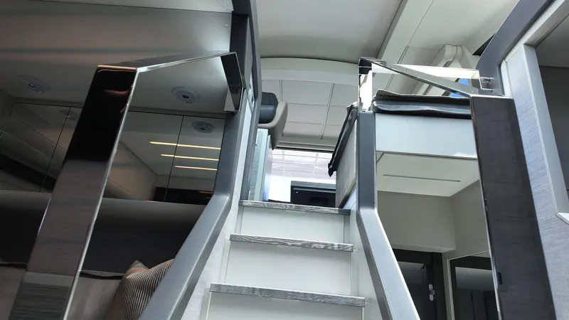 Slide: The Image of Interior staircase of 2022 Pershing 6X yacht, featuring modern design and sleek finishes. - 16
