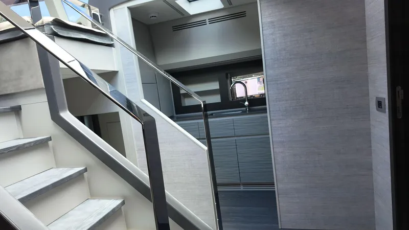 Slide: The Image of Modern interior of 2022 Pershing 6X yacht with sleek staircase and kitchen area. - 18