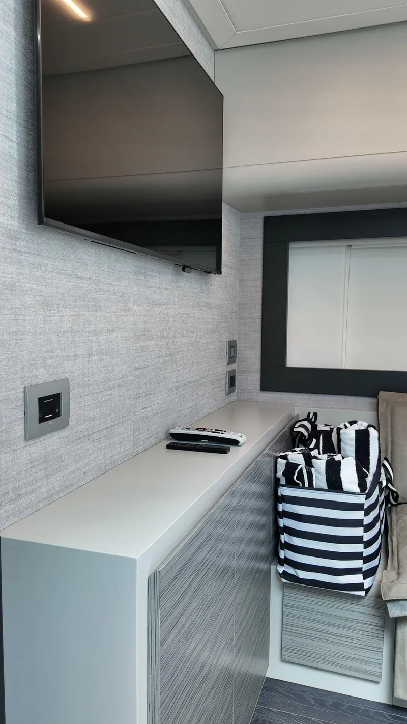 Slide: The Image of Interior of 2022 Pershing 6X yacht with modern TV and striped storage basket. - 24