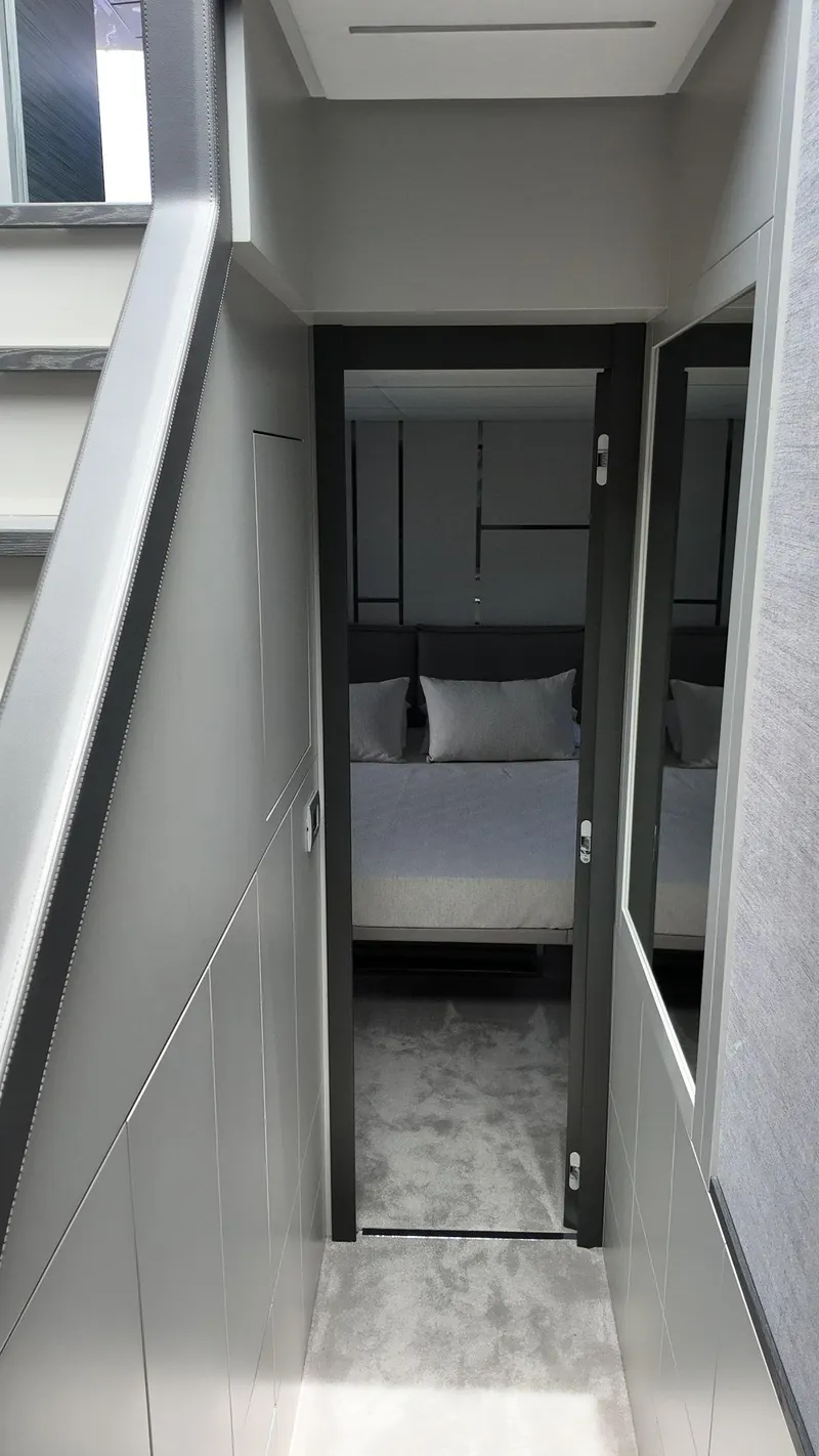 Slide: The Image of Modern interior of 2022 Pershing 6X yacht, featuring sleek hallway leading to a cozy bedroom. - 28
