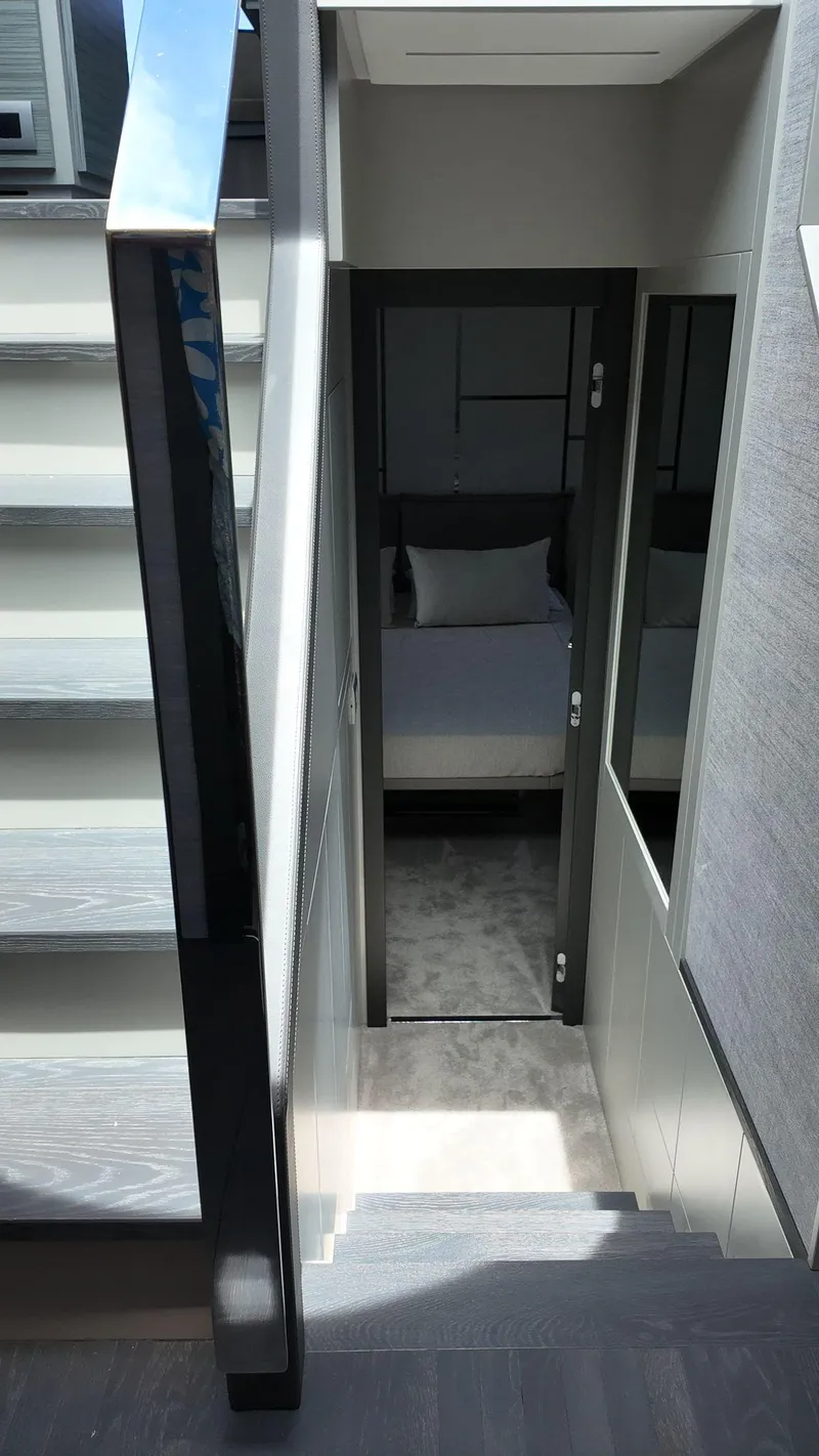 Slide: The Image of Staircase leading to a modern bedroom in a 2022 Pershing 6X yacht. - 40
