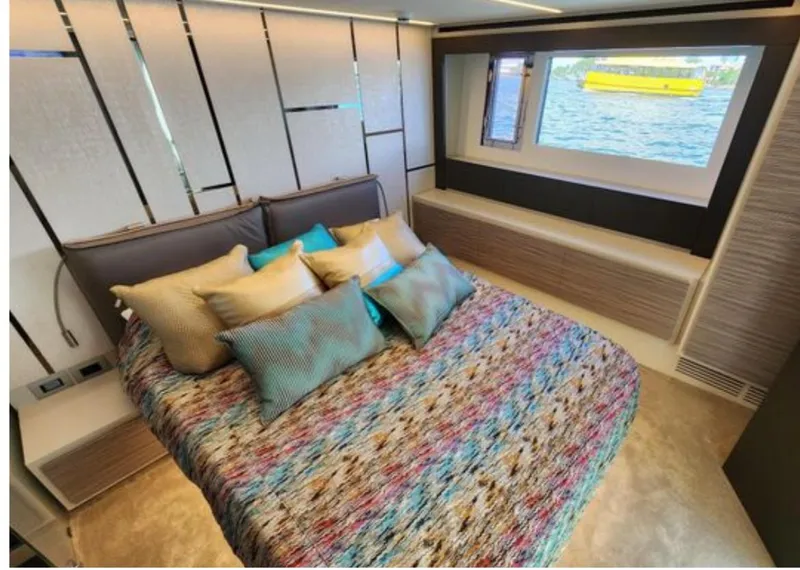 Slide: The Image of Luxurious bedroom interior of 2022 Pershing 6X yacht with colorful bedding and sea view. - 49