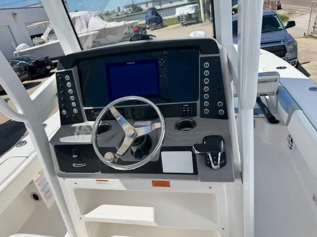 Slide: The Image of 2025 Robalo 246 Cayman boat dashboard with steering wheel and control panel. - 18