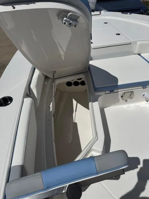 Slide: The Image of 2025 Robalo 246 Cayman boat storage compartment with open hatch, showcasing interior space. - 24