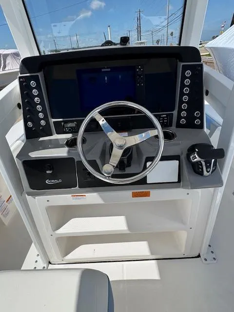 Slide: The Image of 2025 Robalo 246 Cayman boat dashboard with steering wheel and control panel. - 26