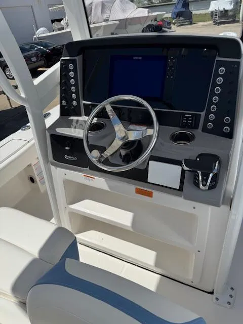 Slide: The Image of 2025 Robalo 246 Cayman boat dashboard with steering wheel and control panel. - 27
