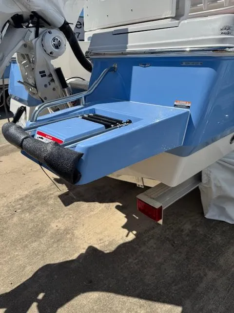 Slide: The Image of 2025 Robalo 246 Cayman boat with blue swim platform and ladder. - 9
