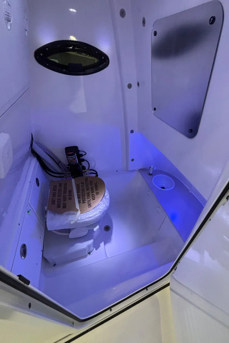 Slide: The Image of 2025 Sea Pro 242 Center Console boat interior with modern amenities and blue lighting. - 13