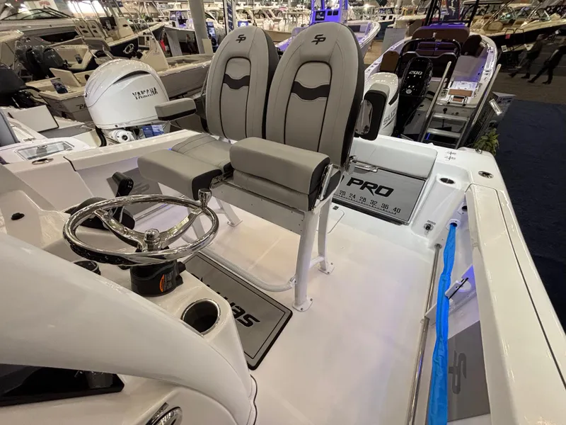 Slide: The Image of 2025 Sea Pro 242 Center Console boat interior with dual seats and steering wheel. - 7