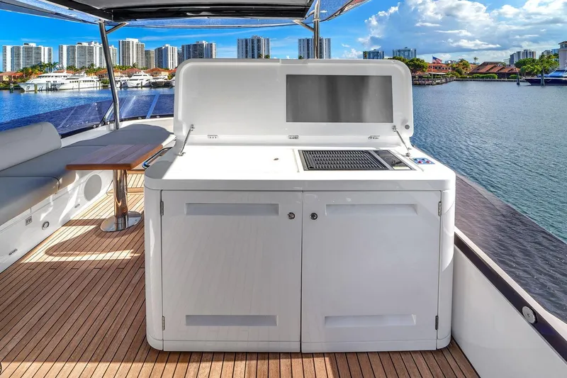 Slide: The Image of Luxurious Sunseeker Manhattan 68 yacht deck with grill, 2023 model, overlooking waterfront skyline. - 24