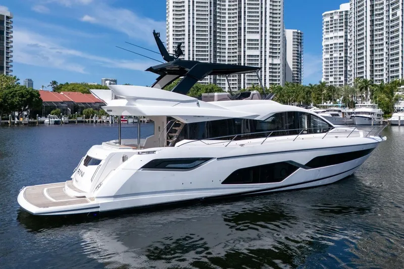 Slide: The Image of 2023 Sunseeker Manhattan 68 Pacific yacht docked in a marina with city skyline. - 3