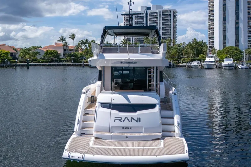 Slide: The Image of 2023 Sunseeker Manhattan 68 Pacific yacht docked in a marina, surrounded by buildings. - 5