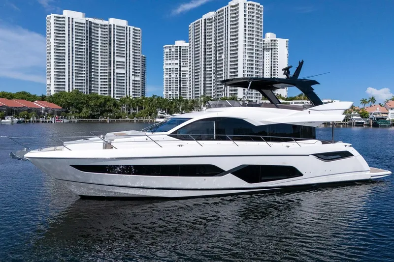 Slide: The Image of 2023 Sunseeker Manhattan 68 Pacific yacht on water with city skyline backdrop. - 7