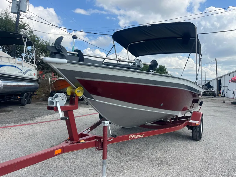 Slide: The Image of 2002 Fisher 16 Pro Avenger boat on trailer, red and silver, parked outdoors. - 10