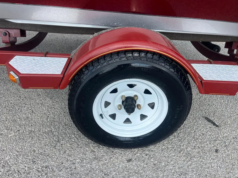Slide: The Image of 2002 Fisher 16 Pro Avenger boat on trailer, red and gray, with canopy, outdoors. - 12