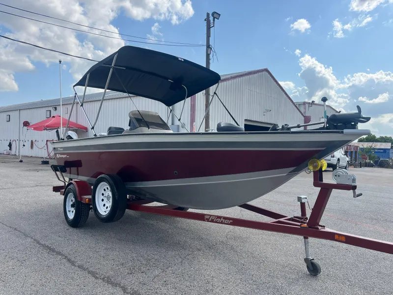Slide: The Image of Trailer wheel of 2002 Fisher 16 Pro Avenger, featuring red fender and diamond plate accents. - 19