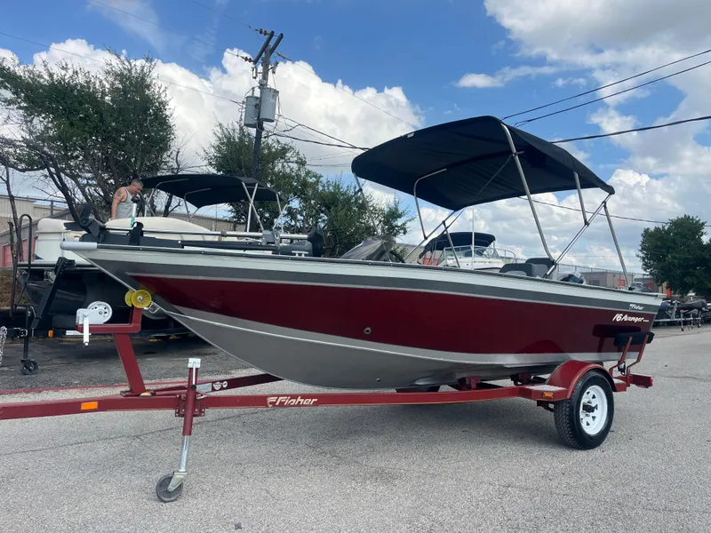 Slide: The Image of 2002 Fisher 16 Pro Avenger boat on trailer, parked outdoors under a blue sky. - 2