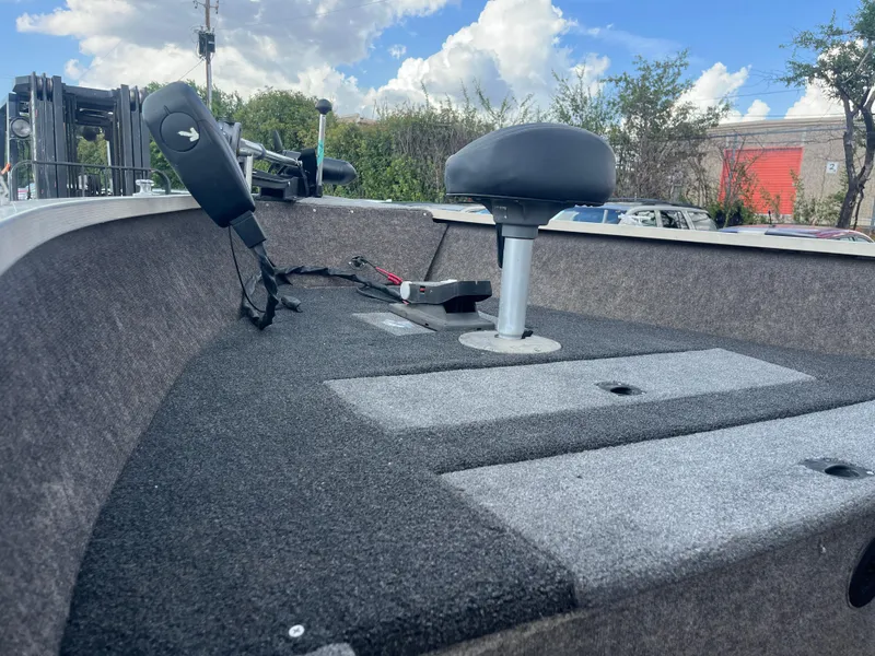 Slide: The Image of 2002 Fisher 16 Pro Avenger boat interior with gray and white seating under a blue sky. - 31