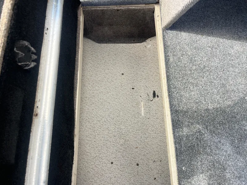 Slide: The Image of Interior view of a 2002 Fisher 16 Pro Avenger boat, showing carpeted flooring and seating. - 39