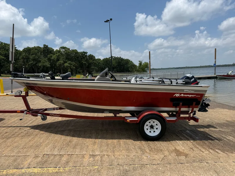 Slide: The Image of 2002 Fisher 16 Pro Avenger boat on trailer by a lake under a cloudy sky. - 48