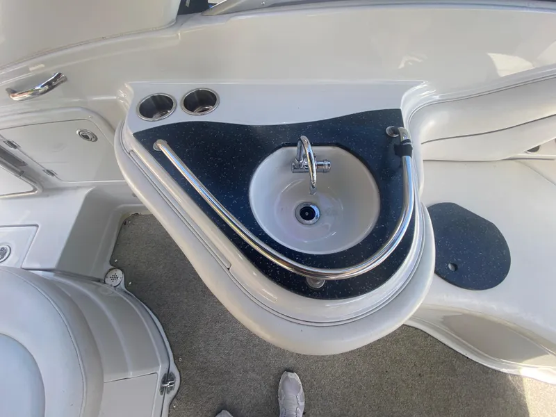 Slide: The Image of 2006 Crownline 320 LS boat interior with sink and cup holders. - 17