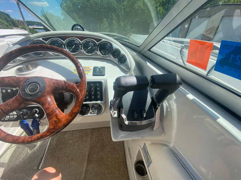 Slide: The Image of 2006 Crownline 320 LS boat dashboard with wood steering wheel and control panel. - 23