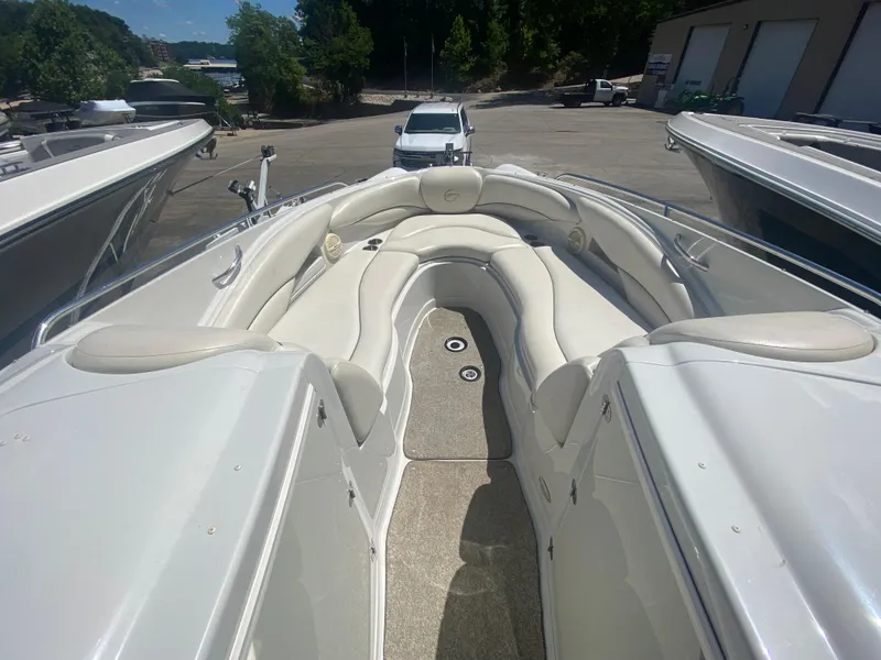 Slide: The Image of 2006 Crownline 320 LS boat with spacious seating and sleek design in a marina setting. - 28