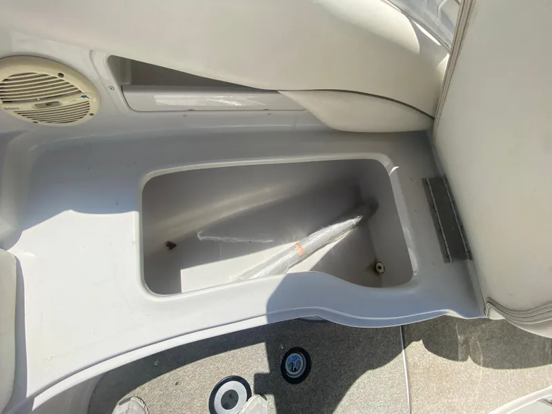 Slide: The Image of Storage compartment in a 2006 Crownline 320 LS boat, featuring a speaker and seating area. - 34