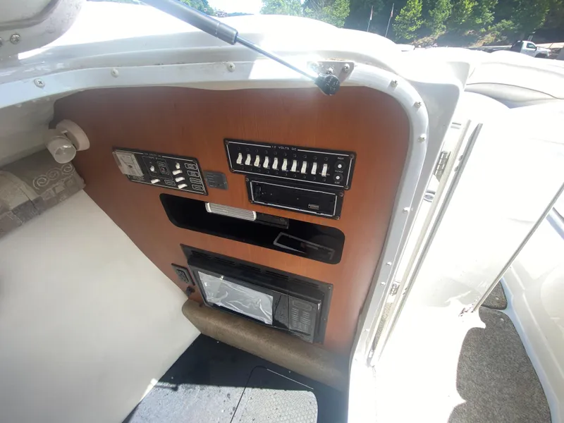Slide: The Image of 2006 Crownline 320 LS boat interior control panel with switches and storage compartments. - 39