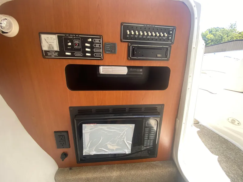 Slide: The Image of Control panel and microwave in 2006 Crownline 320 LS boat interior. - 40