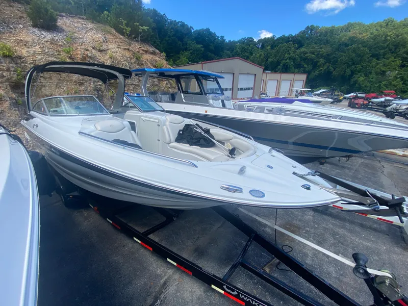 Slide: The Image of 2006 Crownline 320 LS boat on trailer, parked outdoors near other boats. - 45