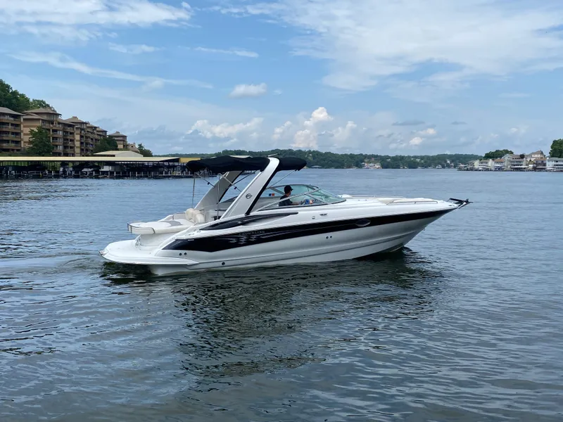 Slide: The Image of 2006 Crownline 320 LS boat cruising on a calm lake under a partly cloudy sky. - 5