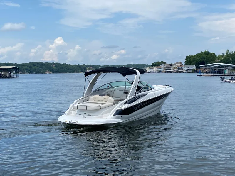 Slide: The Image of 2006 Crownline 320 LS boat cruising on a serene lake with scenic background. - 7
