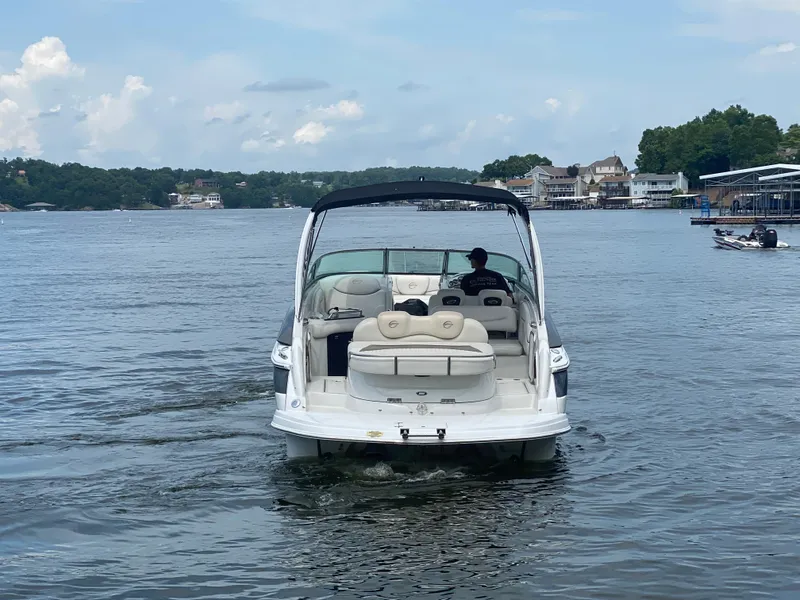 Slide: The Image of 2006 Crownline 320 LS boat cruising on a lake with scenic shoreline views. - 8