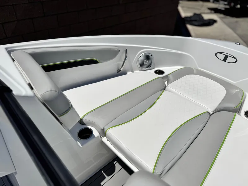Slide: The Image of 2023 Tahoe 210 Si boat interior with white and gray seating, green accents, and cup holders. - 11