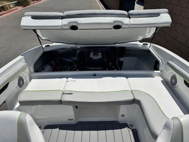 Slide: The Image of 2023 Tahoe 210 Si boat interior with open engine compartment, white seating, and modern design. - 16