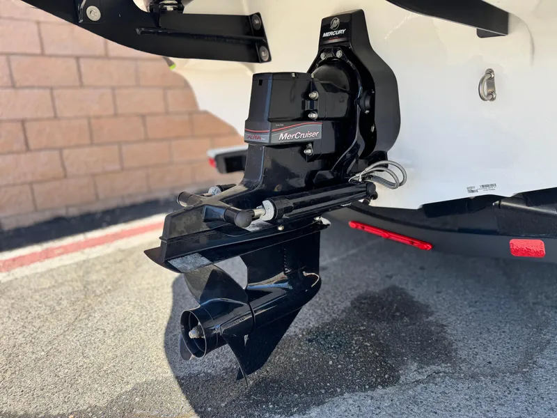 Slide: The Image of 2023 Tahoe 210 Si boat with MerCruiser engine, parked on pavement. - 7