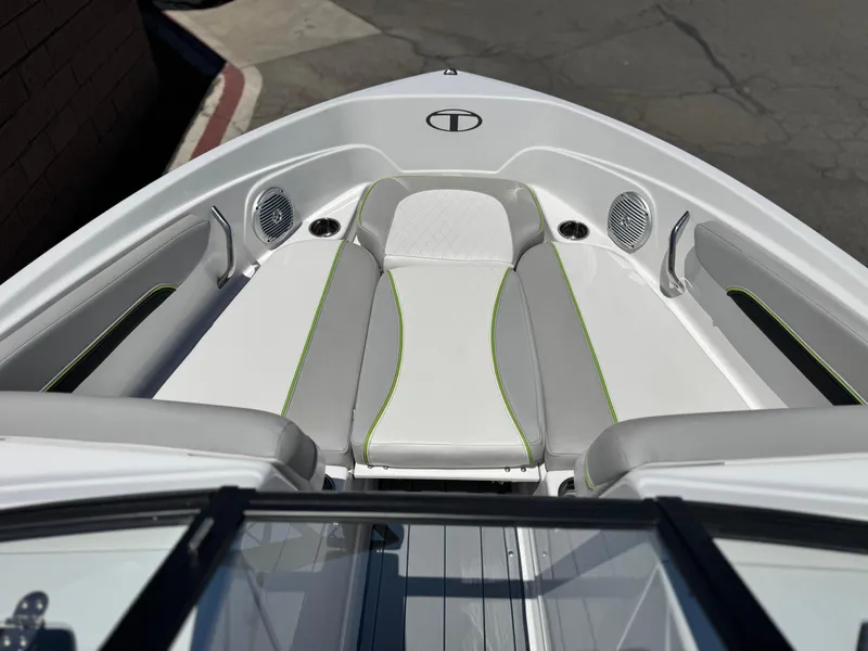 Slide: The Image of 2023 Tahoe 210 Si boat interior with gray and green seating, speakers, and cup holders. - 9