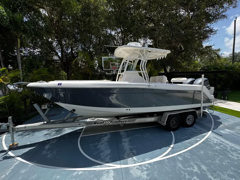 Slide: The Image of 2016 Robalo R260 Center Console boat on trailer, parked outdoors. - 2