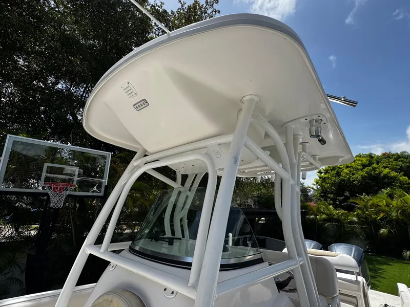 Slide: The Image of 2016 Robalo R260 Center Console boat with T-top, outdoors under blue sky. - 20