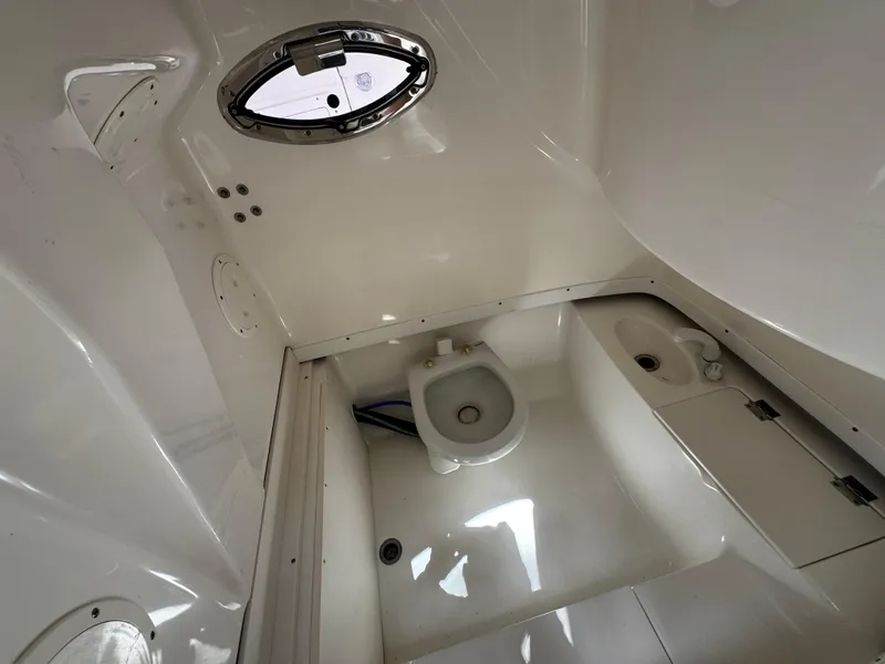 Slide: The Image of 2016 Robalo R260 Center Console boat interior with compact marine toilet. - 22